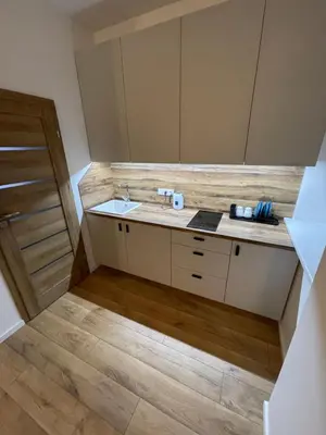 a bathroom with a sink and a wooden floor at 32 Airport Apartment in Vilnius