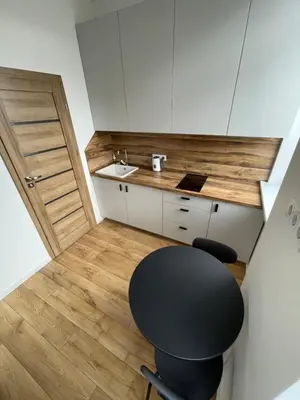 a small kitchen with a black chair and a sink at 32 Airport Apartment in Vilnius
