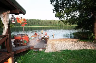 a dock with a boat on a lake at Pirtelė Arjola in Kaltanėnai