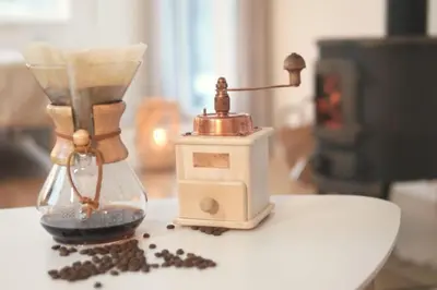 an old blender sitting on a table with coffee beans at Hand made Off Grid forest Cabin Luna in Luksine