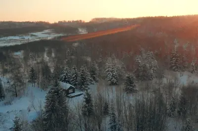 an aerial view of a snow covered field with trees at Hand made Off Grid forest Cabin Luna in Luksine
