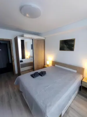 a bedroom with a large white bed with two lamps at Bruklinas in Šiauliai