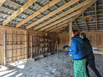 a couple of people standing in a barn at Sodyba PILIAKIEMIS in Kurkliškės