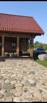 a gazebo with a swing on a stone patio at Drulenu sodyba in Drūlėnai