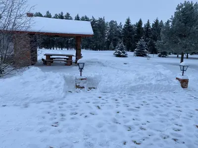 a picnic shelter covered in snow next to a yard at Drulenu sodyba in Drūlėnai