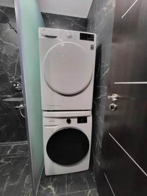 a washer and dryer in a bathroom next to a door at E. D. Elite Apartment in Šiauliai