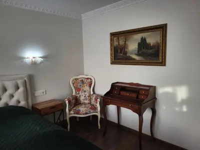 a bedroom with a bed and a desk and a chair at E. D. Elite Apartment in Šiauliai