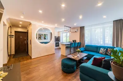 a living room with a blue couch and a table at E. D. Elite Apartment in Šiauliai