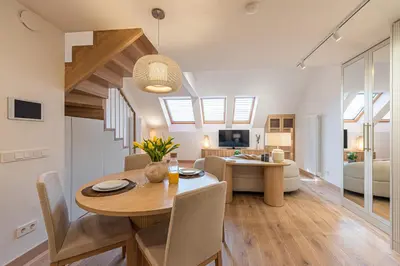 a dining room and living room with a table and a couch at cohost I Premium Residence I on the Historic Pilies Street I Self Check-in in Vilnius