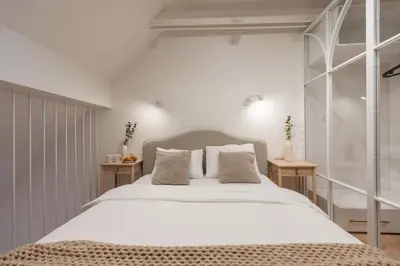a bedroom with a large white bed with two tables at cohost I Premium Residence I on the Historic Pilies Street I Self Check-in in Vilnius