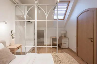 a bedroom with a glass shower with a desk at cohost I Premium Residence I on the Historic Pilies Street I Self Check-in in Vilnius