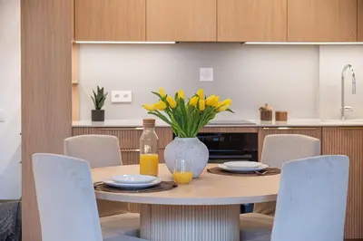 a dining room table with a vase of yellow flowers at cohost I Premium Residence I on the Historic Pilies Street I Self Check-in in Vilnius