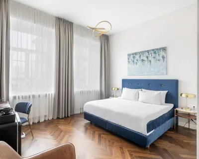 a hotel room with a bed and a chair at GRAND CROWN in Vilnius