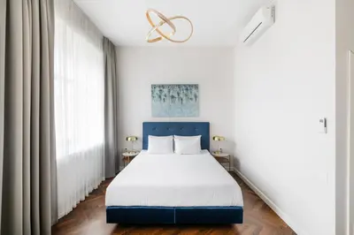 a bedroom with a bed and a large window at GRAND CROWN in Vilnius