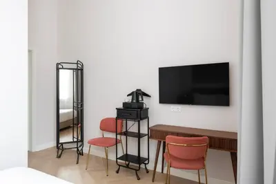 a room with a table and chairs and a television at GRAND CROWN in Vilnius