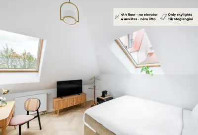 a bedroom with a bed and a desk and a tv at GRAND CROWN in Vilnius