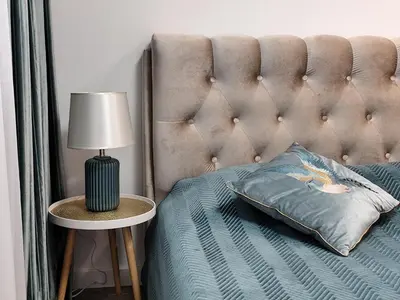a bed with a tufted headboard and a table with a lamp at NEW Apartment J22, Free Private Parking, Terrace, Self Check-in in Kaunas