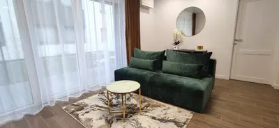 a living room with a green couch and a table at NEW Apartment J22, Free Private Parking, Terrace, Self Check-in in Kaunas