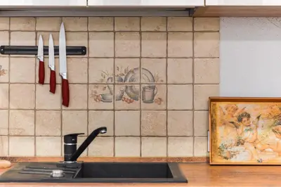 a kitchen counter with a sink and knives on the wall at Courtyard gallery apartment with free parking in Kaunas