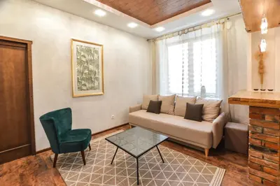 a living room with a couch and a chair at Courtyard gallery apartment with free parking in Kaunas