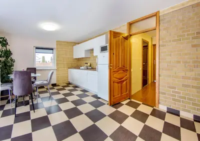 a kitchen with a checkered floor and a table with chairs at Namo-pirties nuoma Vinkšnėnuose in Vijoliai