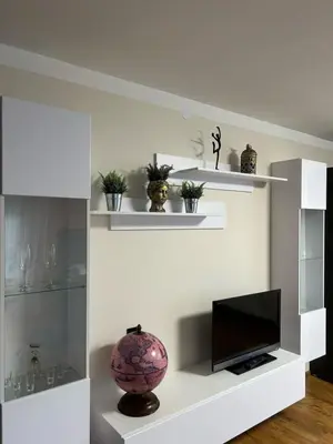 a living room with white shelves and a television at Namo-pirties nuoma Vinkšnėnuose in Vijoliai