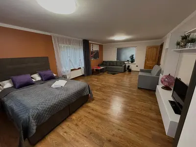 a bedroom with a bed and a living room at Namo-pirties nuoma Vinkšnėnuose in Vijoliai