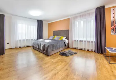 a bedroom with a bed and a wooden floor at Namo-pirties nuoma Vinkšnėnuose in Vijoliai