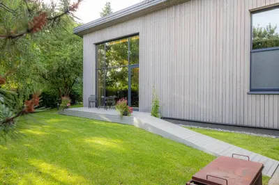 a garden view of a house with a lawn at Pine house in Zujūnai
