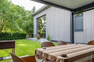 a patio with a wooden table and chairs at Pine house in Zujūnai