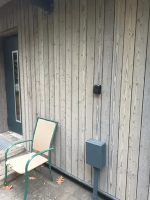a chair and a blue box next to a building at Pine house in Zujūnai