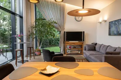 a living room with a table and a couch at Pine house in Zujūnai