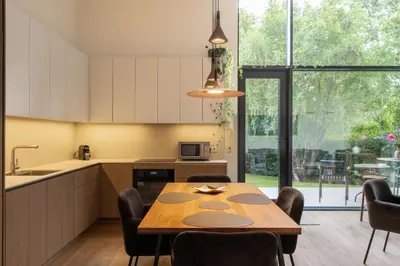 a kitchen and dining room with a table and chairs at Pine house in Zujūnai