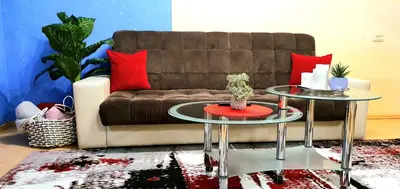 a living room with two tables in front of a couch at EMVIKA apartament in Šiauliai