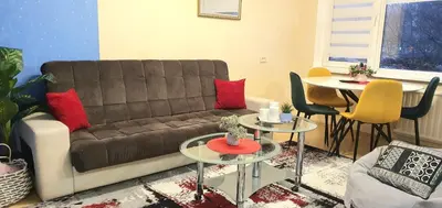 a living room with a brown couch and tables at EMVIKA apartament in Šiauliai