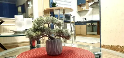 a vase with flowers on a table in a kitchen at EMVIKA apartament in Šiauliai