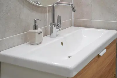 a white sink with two toothbrushes on top of it at Apartment Secret in Jonava