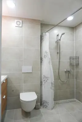 a bathroom with a shower with a toilet and a shower curtain at Apartment Secret in Jonava