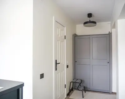 a kitchen with a door and a chair in a room at Apartment Secret in Jonava