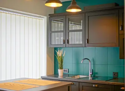 a kitchen with blue walls and a sink and a window at Apartment Secret in Jonava