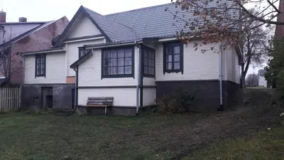 a white house with a bench in a yard at Poilsio kambariai Salake in Salakas