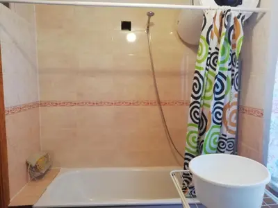 a bathroom with a tub and a shower curtain at Poilsio kambariai Salake in Salakas