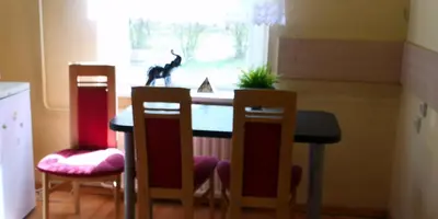 a kitchen with three chairs and a table and a window at Vieno kambario butas su balkonu in Kaunas