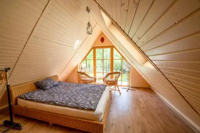 a bedroom with a bed in a attic at Namelis ant kranto - Alaušo Salos in Sudeikiai