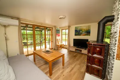 a living room with a couch and a wood stove at Namelis ant kranto - Alaušo Salos in Sudeikiai
