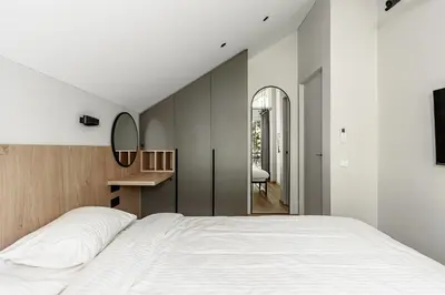 a bedroom with a large white bed and a mirror at Miško Spa namas in Molėtai