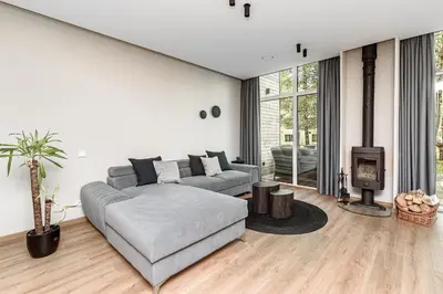 a living room with a couch and a fireplace at Miško Spa namas in Molėtai