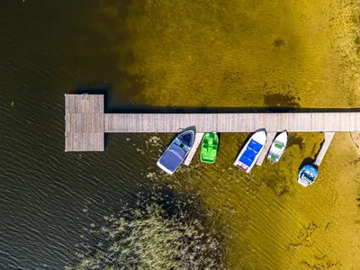 a group of boats parked next to a dock at Miško Spa namas in Molėtai