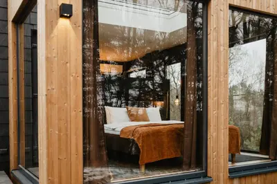 a room with a bed in a glass window at Atokampis Boutique SPA & Resort in Anglininkai