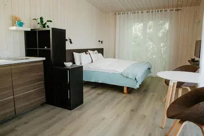 a bedroom with a bed and a table and a window at Atokampis Boutique SPA & Resort in Anglininkai